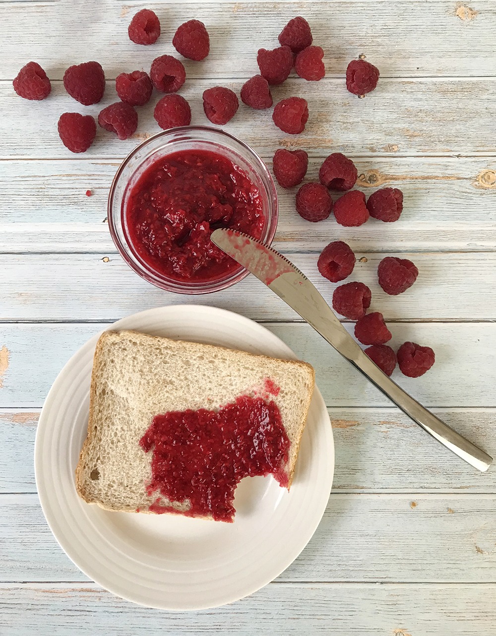 Sugar-Free raspberry Jam in a jar and some fresh raspberry are around.