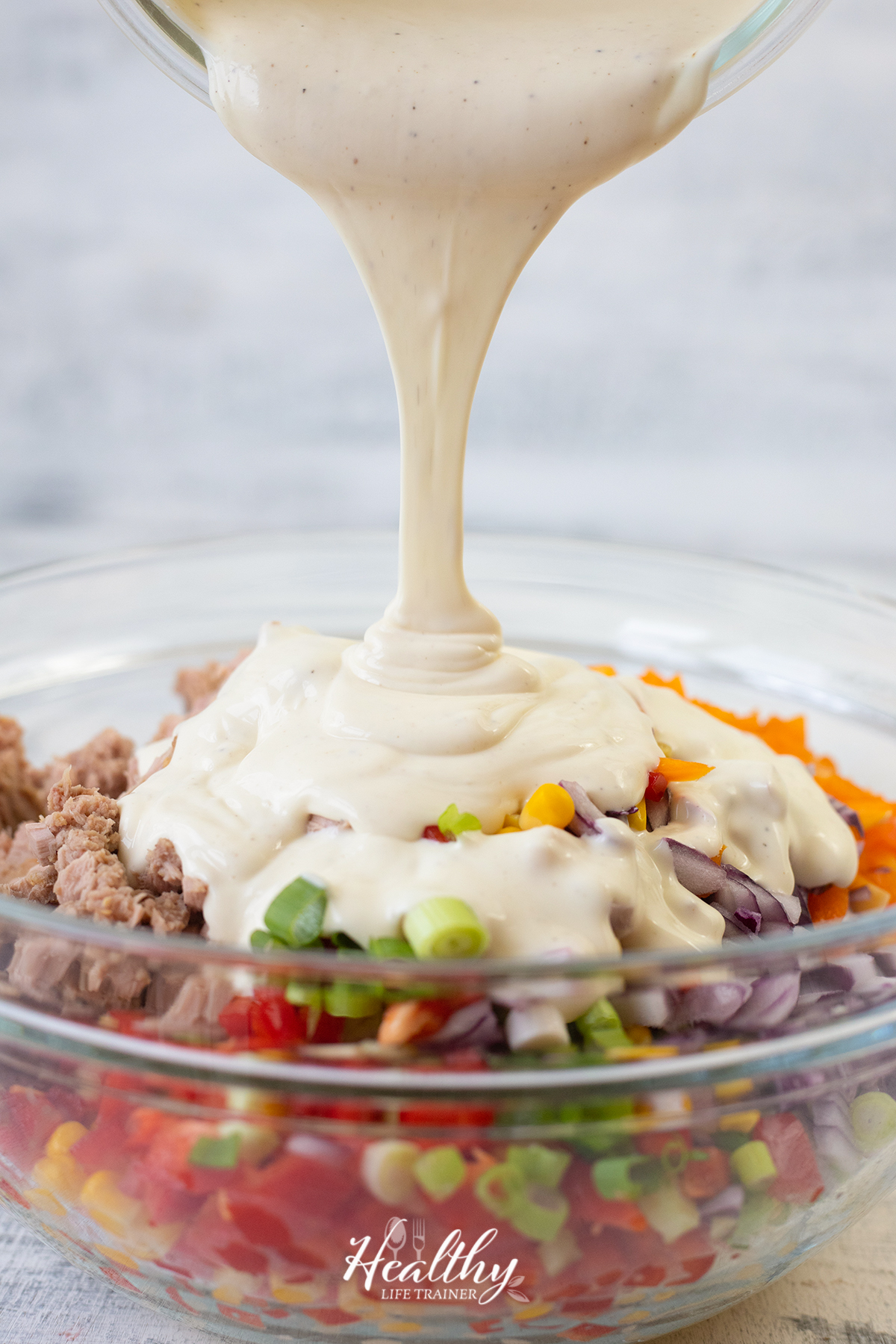 Pouring the dressing over the salad