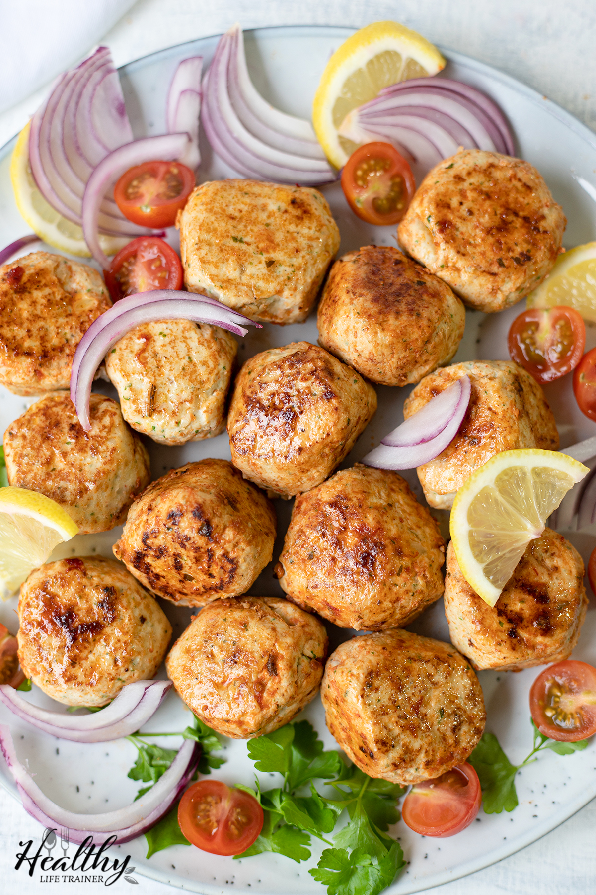 onion, lemon tomatoes in the plate along with the chicken kofta