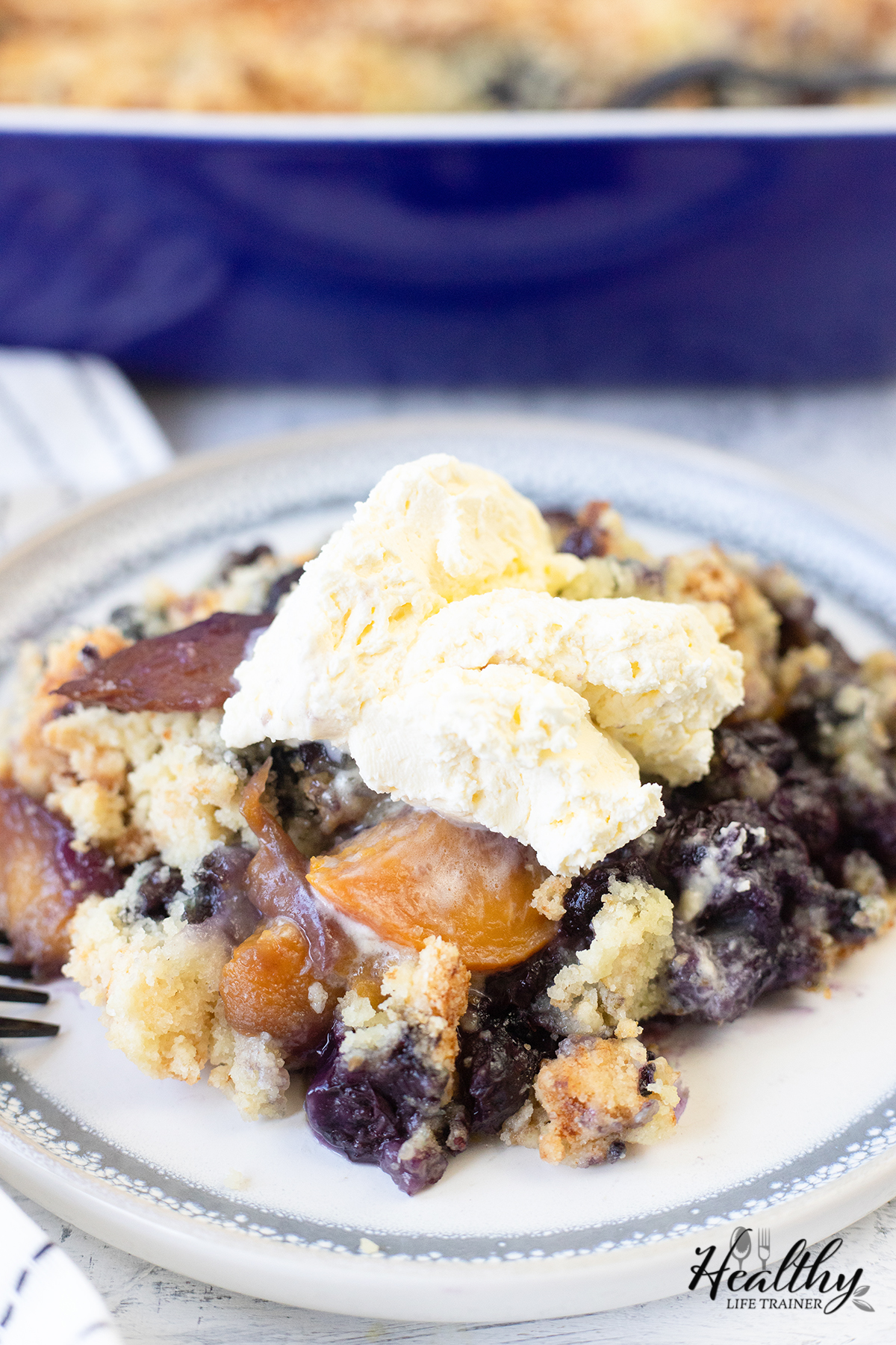 peach blueberry cake topped with whipped cream