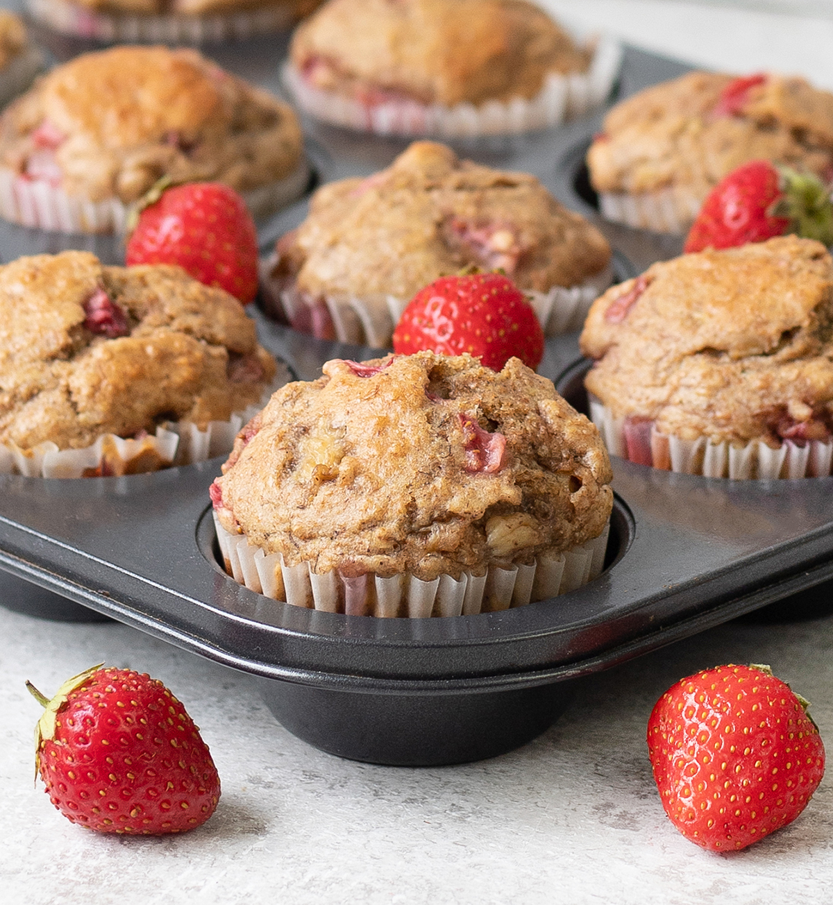 Whole Wheat Strawberry Banana Muffins in a muffin tin.