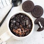 Oreo microwave mug cake and some Oreos are next to it.