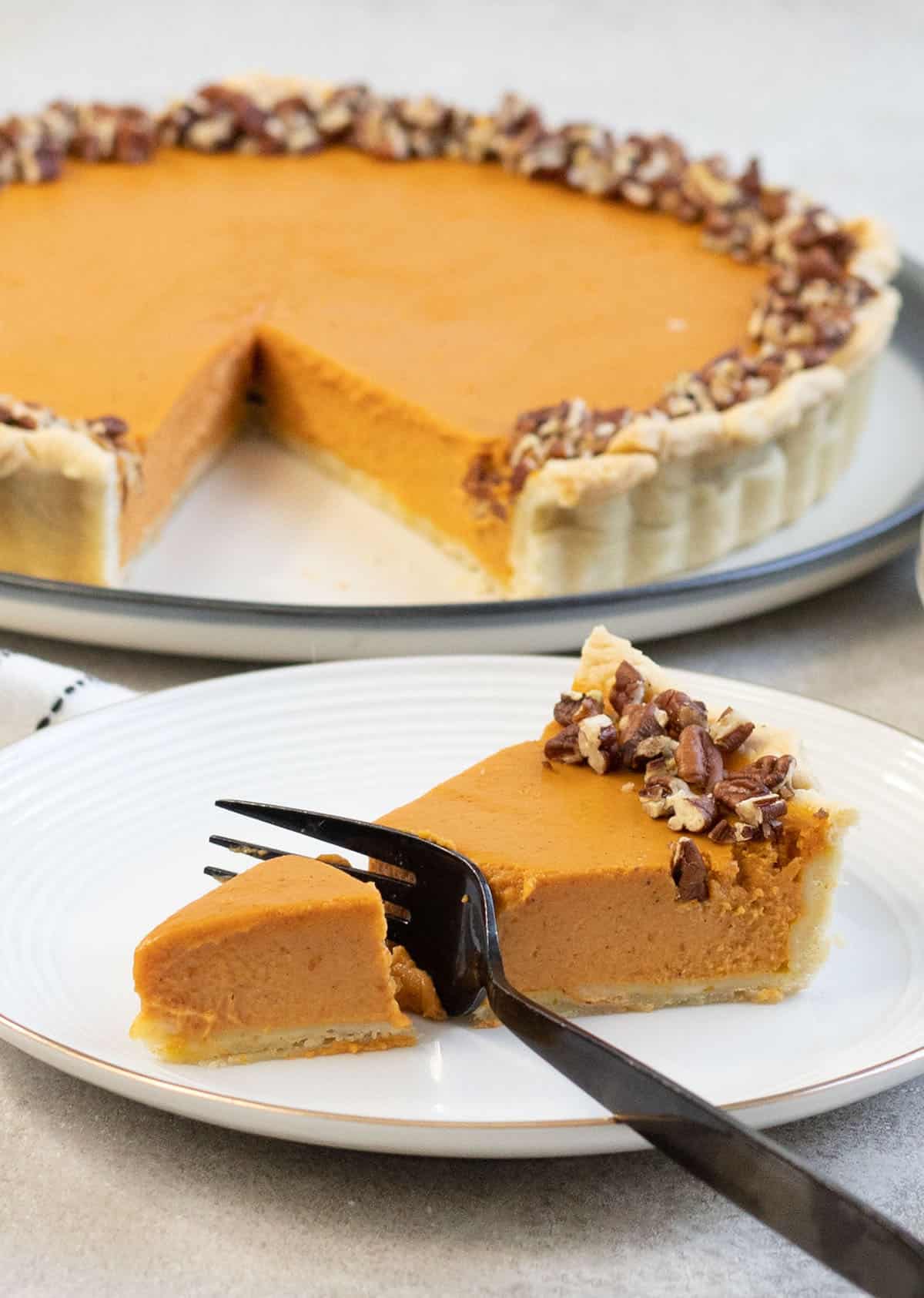 Cut a slice of the pumpkin pie with fork.