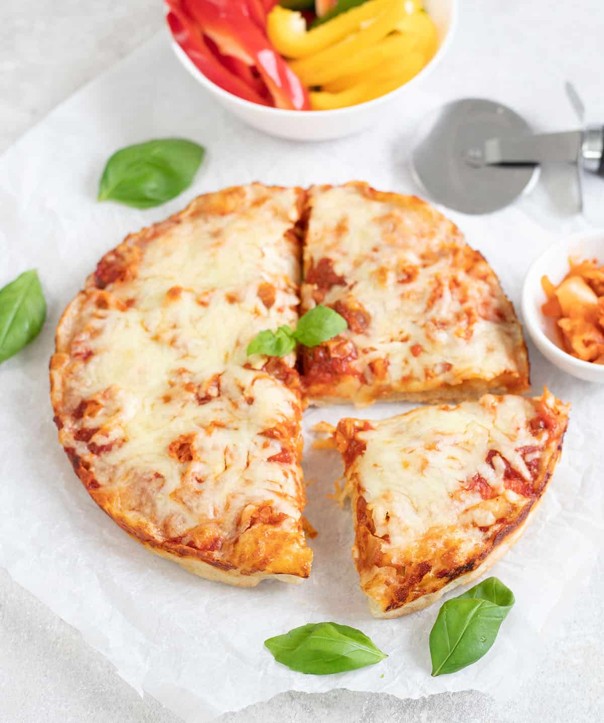 Kimchi Pizza topped with cheese and fresh basil leaves.