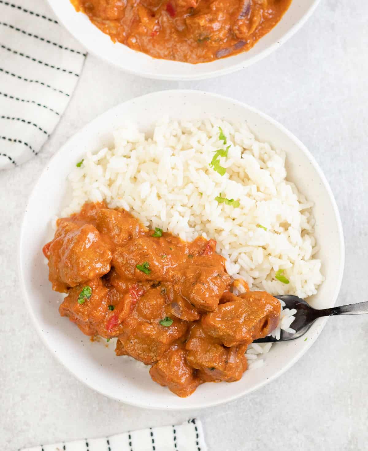  a bowl of rice topped with Lamb Tikka Masala