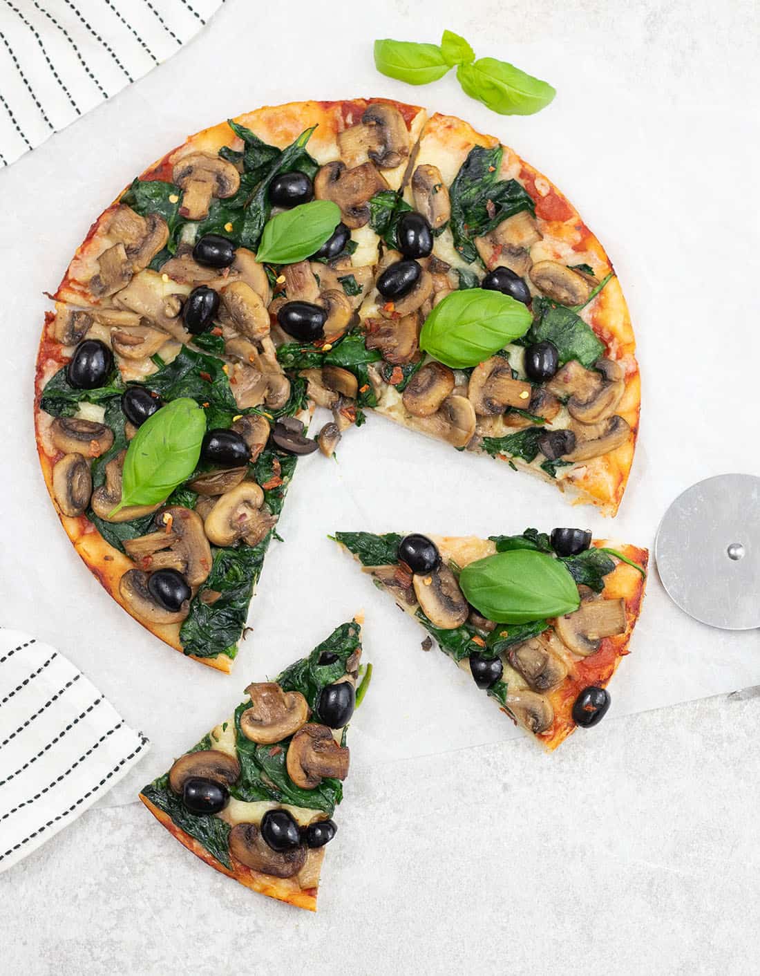 Cut the spinach and mushroom pizza.