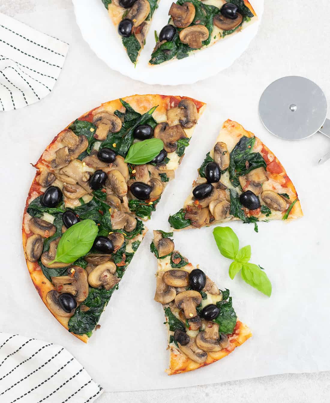 Fresh spinach and mushroom pizza slices.