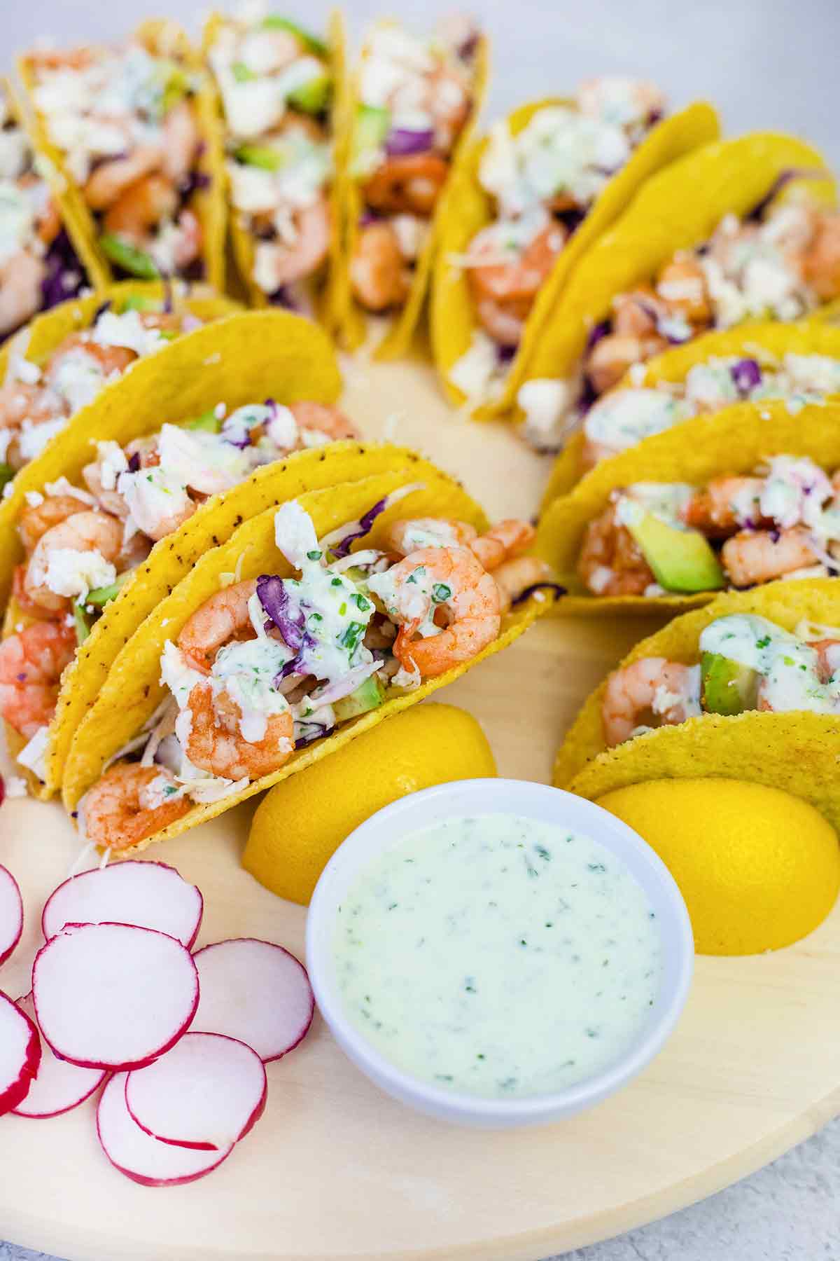 Prawn tacos topped with creamy sauce and lots of veggies.