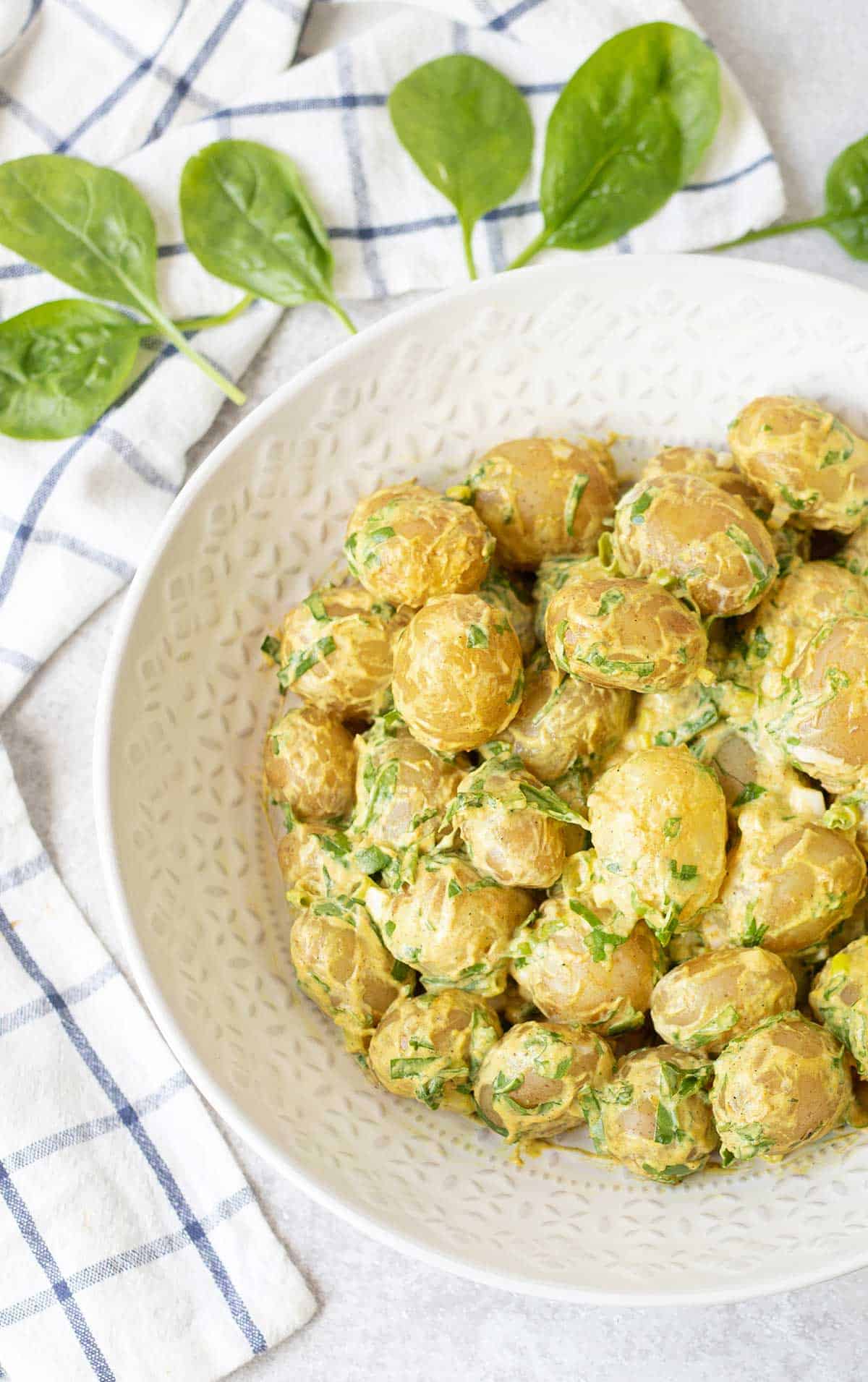 a bowl full of Spicy Potato Salad and Spinach