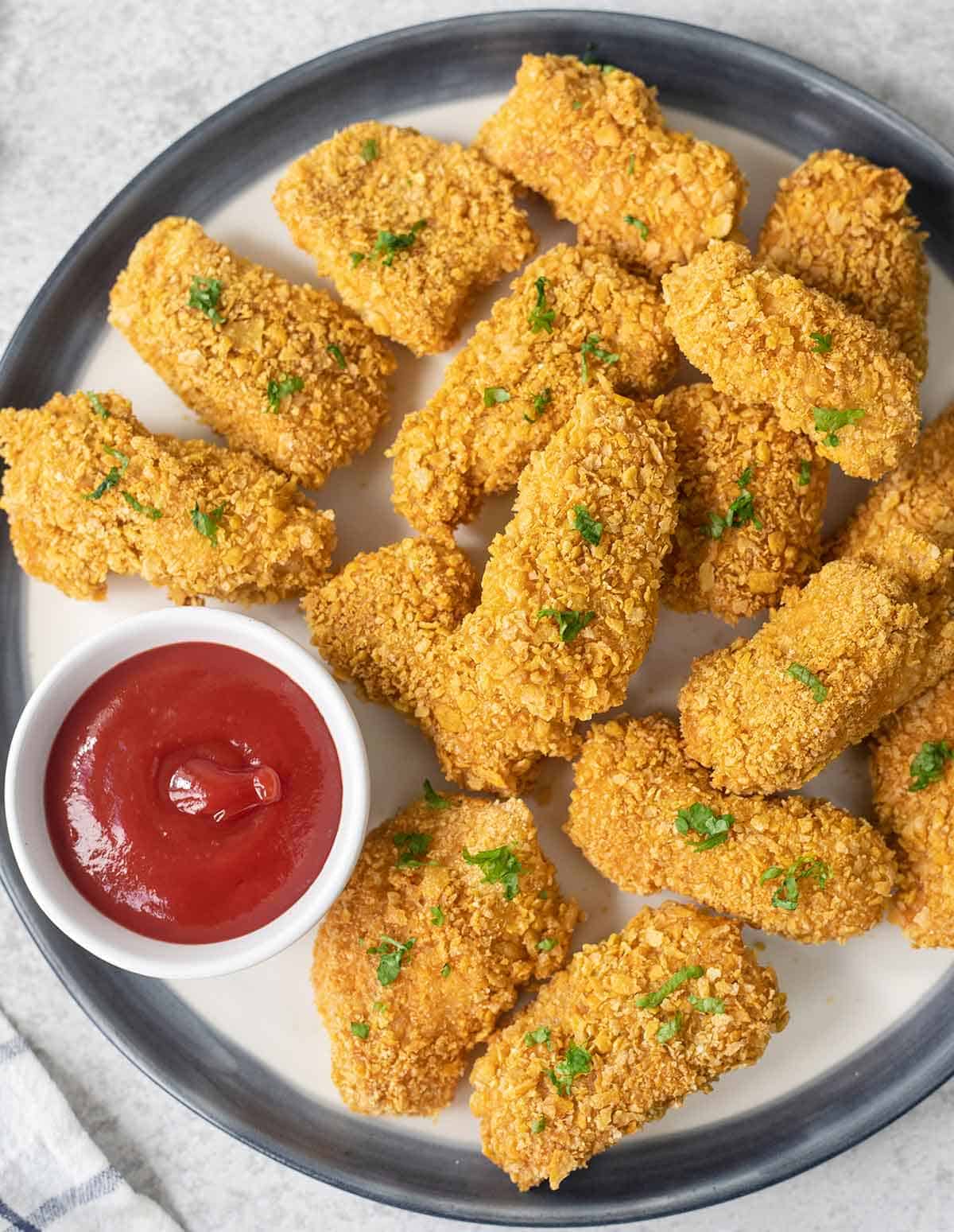 a plate full of baked cornflake chicken nuggets