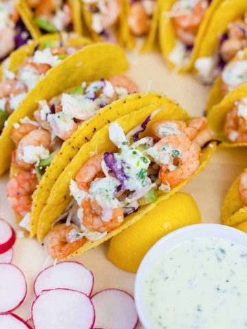 shrimp tacos topped with sour cream sauce