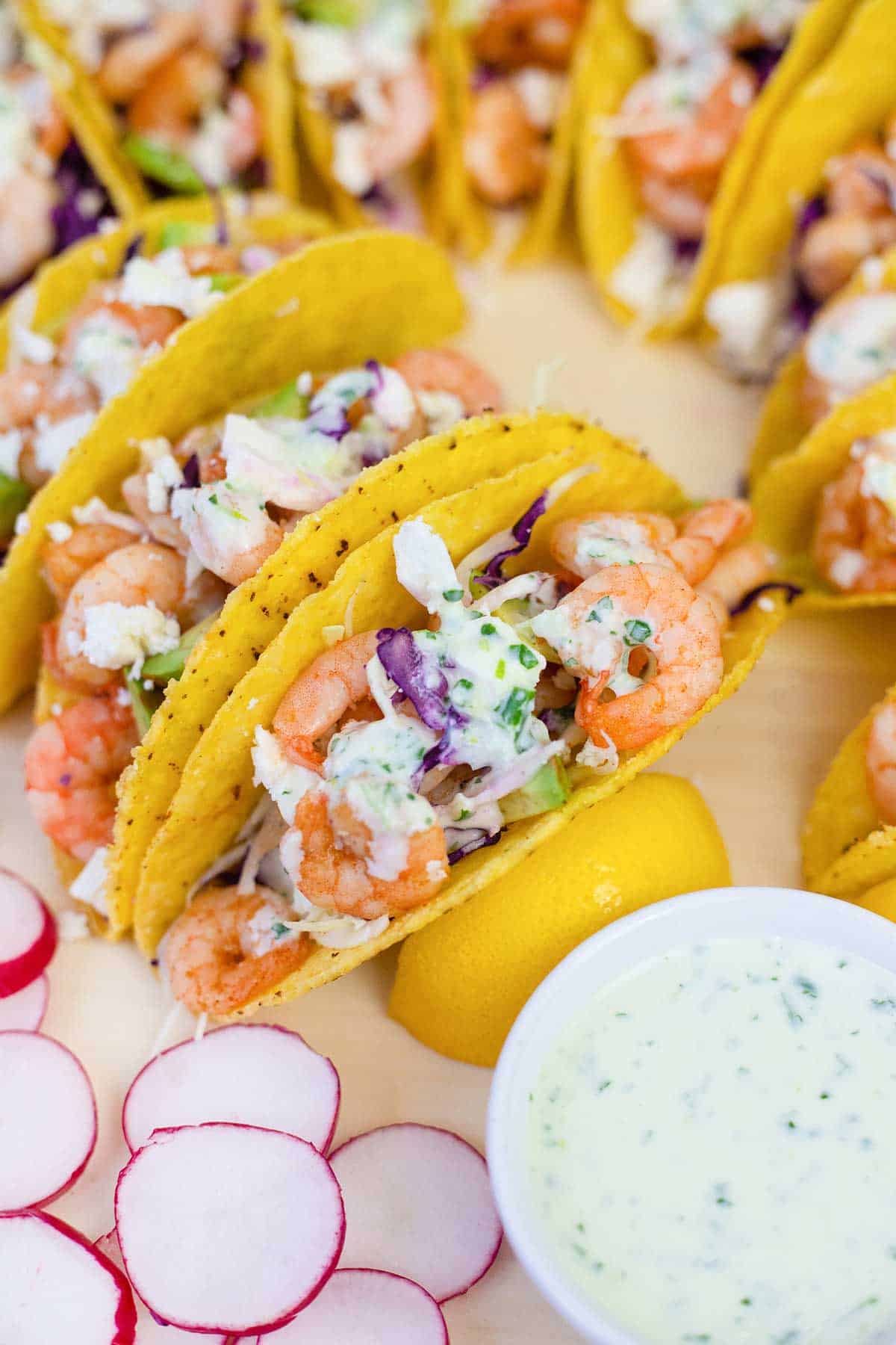 Mexican shrimp tacos in a taco shells topped with creamy sauce