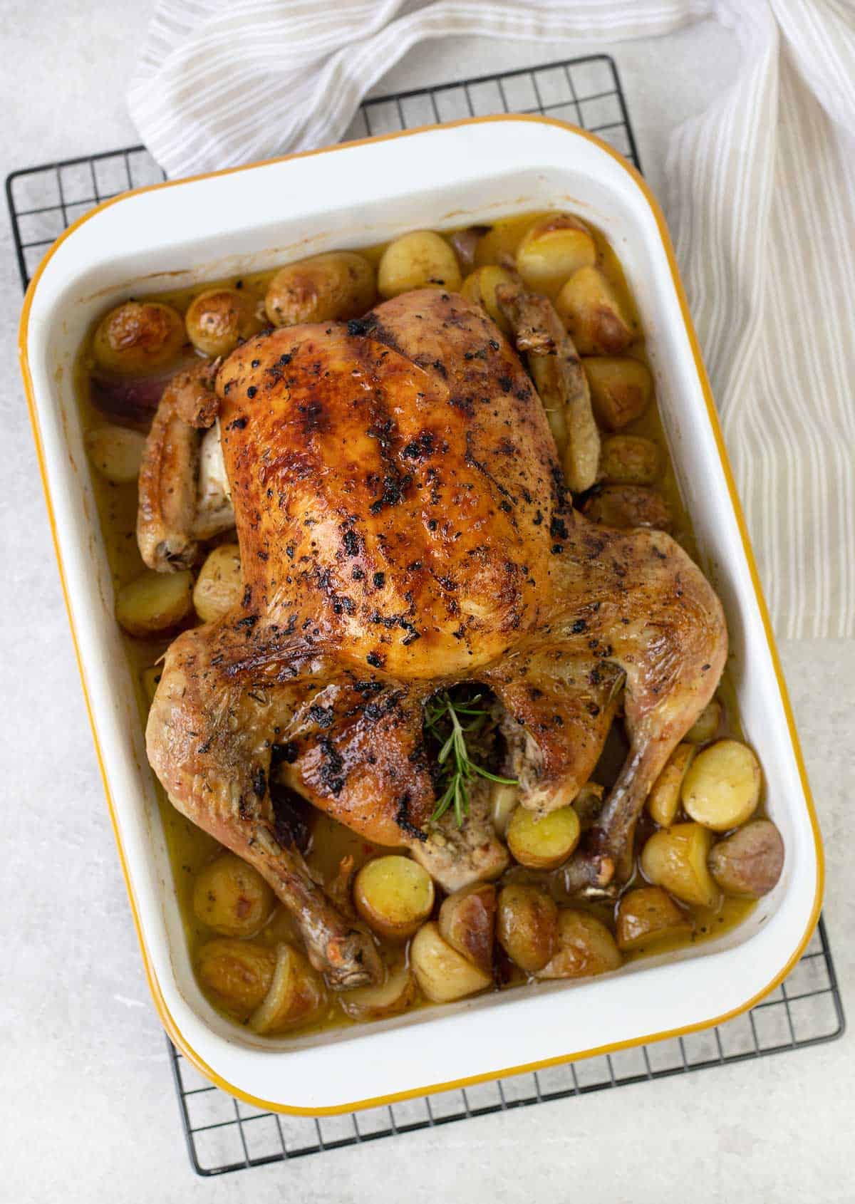 roasted chicken, potatoes and rosemary in a baking pan