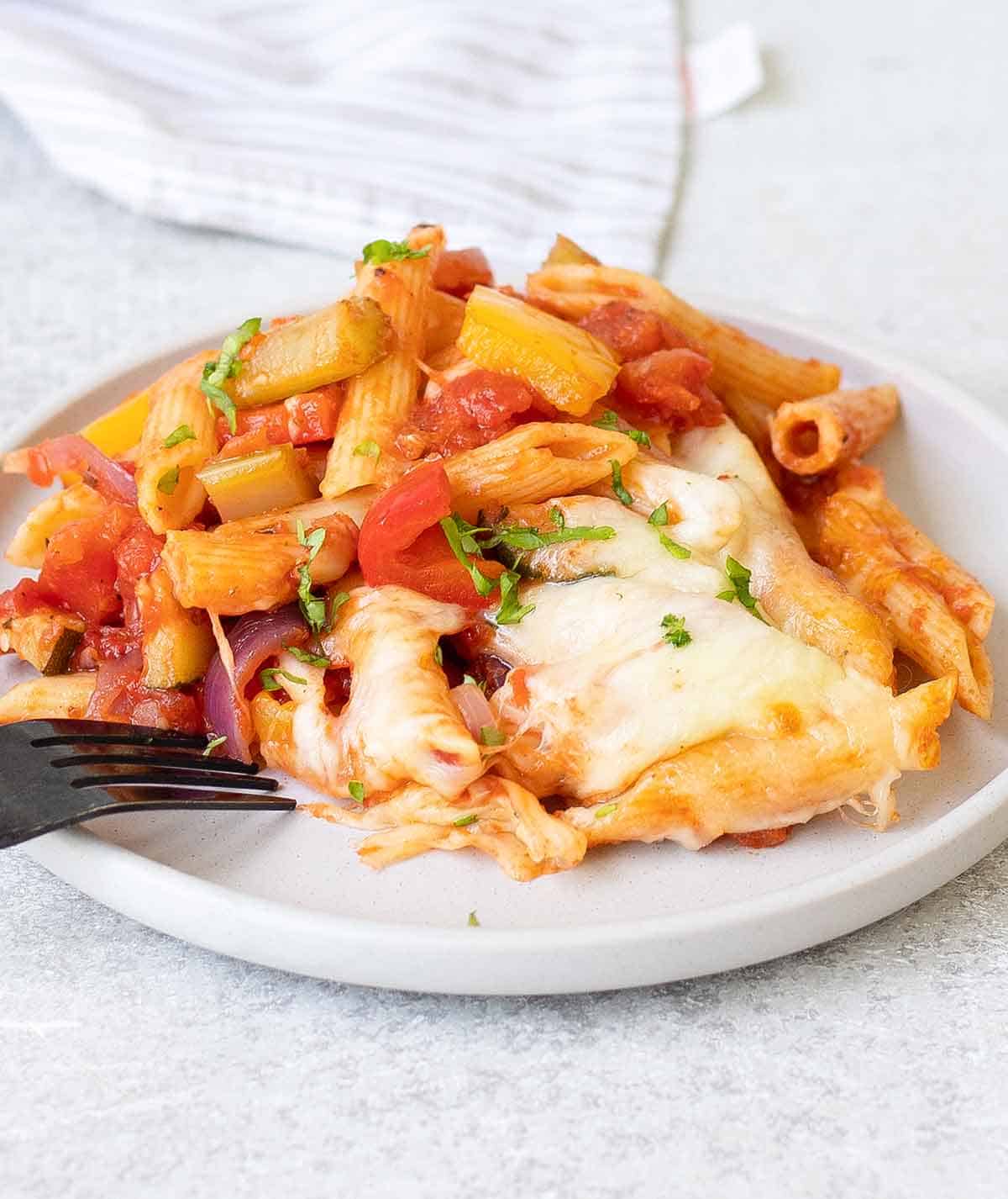 a plate of baked pasta with veggies