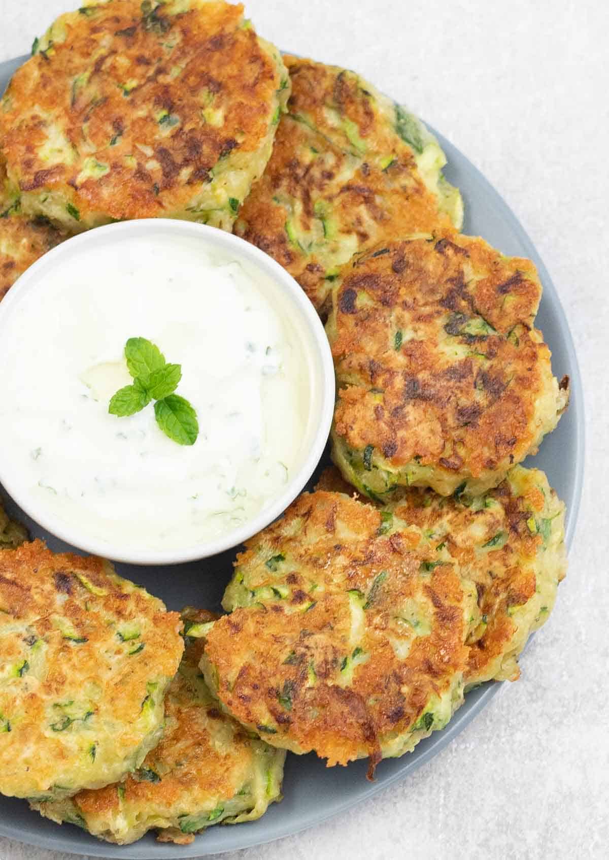 a plate full of Cheesy Courgette Fritters