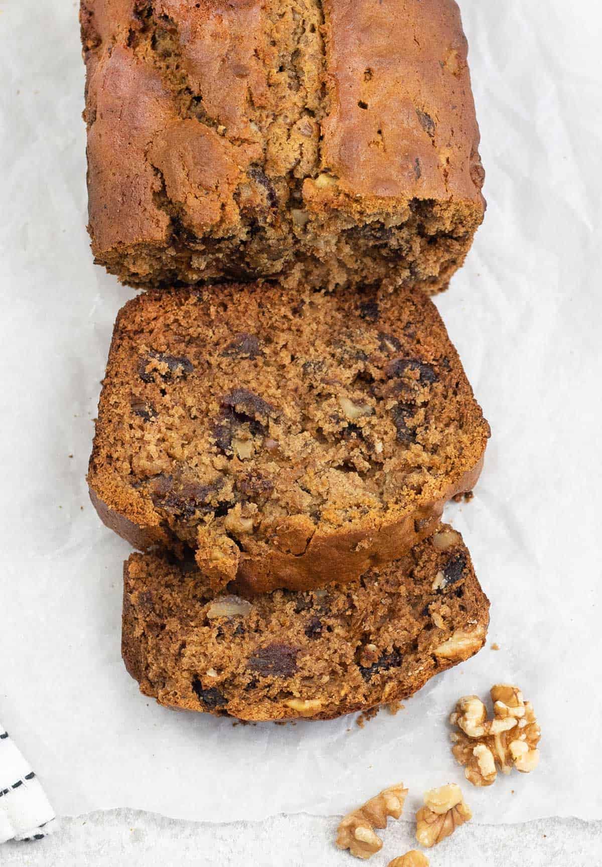 slices of Dates And Walnut Loaf Cake along with some raw walnuts.