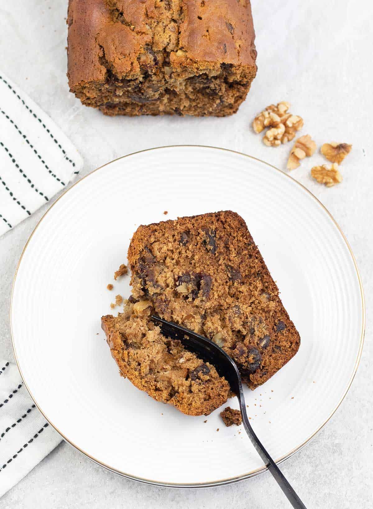 Dates And Walnut Loaf Cake slice in a plate.