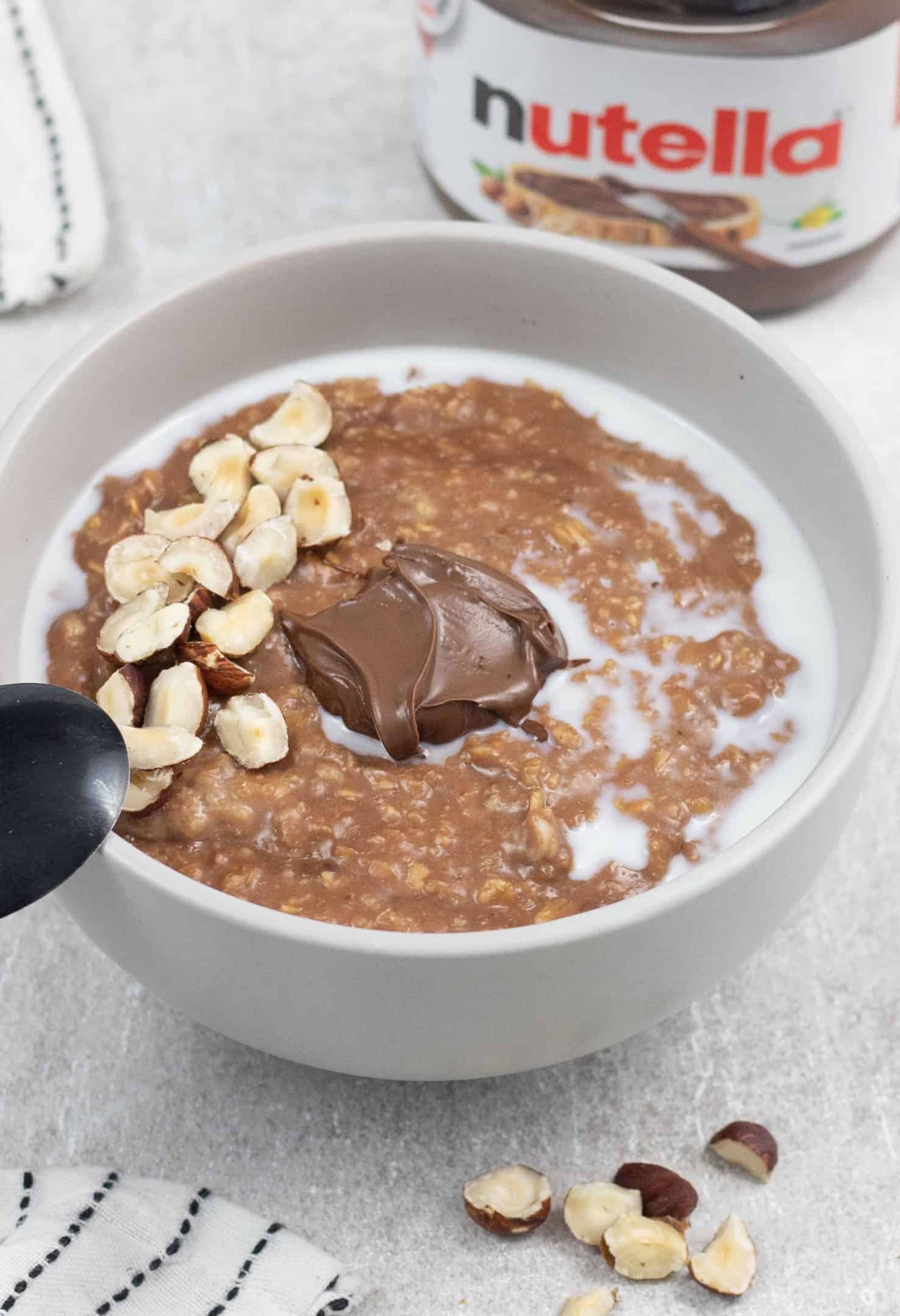 Nutella Porridge in a bowl in the background a Nutella jar