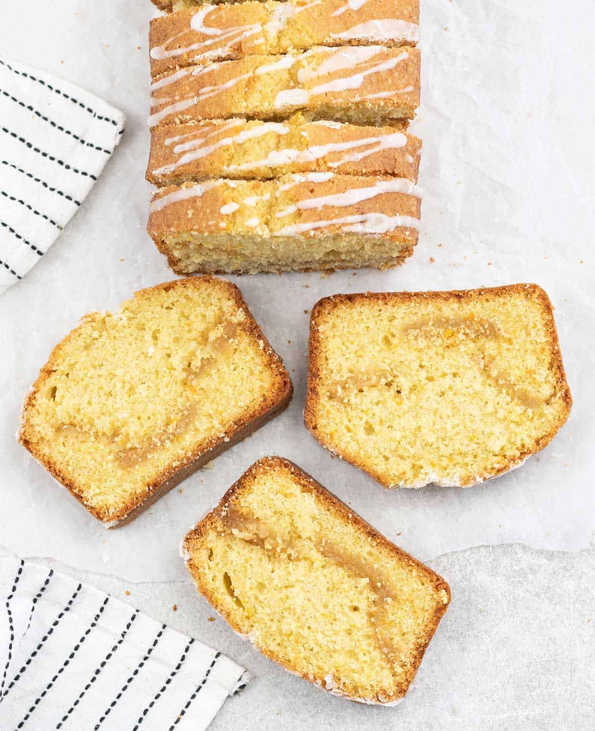 Marzipan cake slices on the table and the whole loaf is in the background.