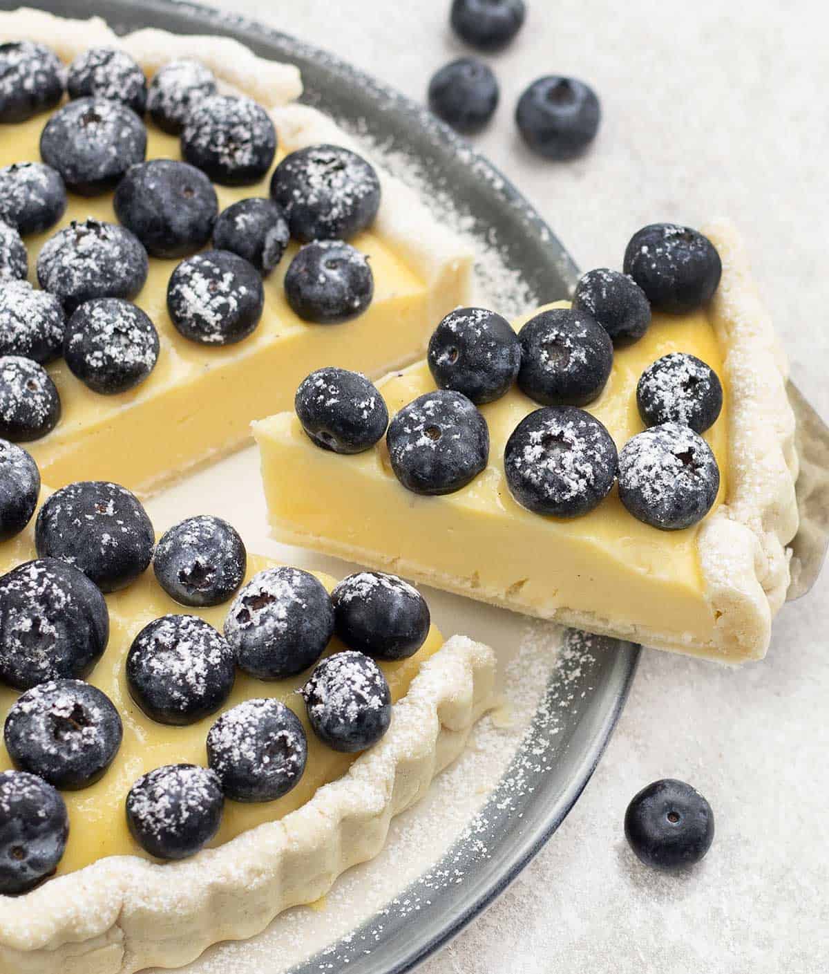 Blueberry Custard Tart slice topped with fresh blueberries.