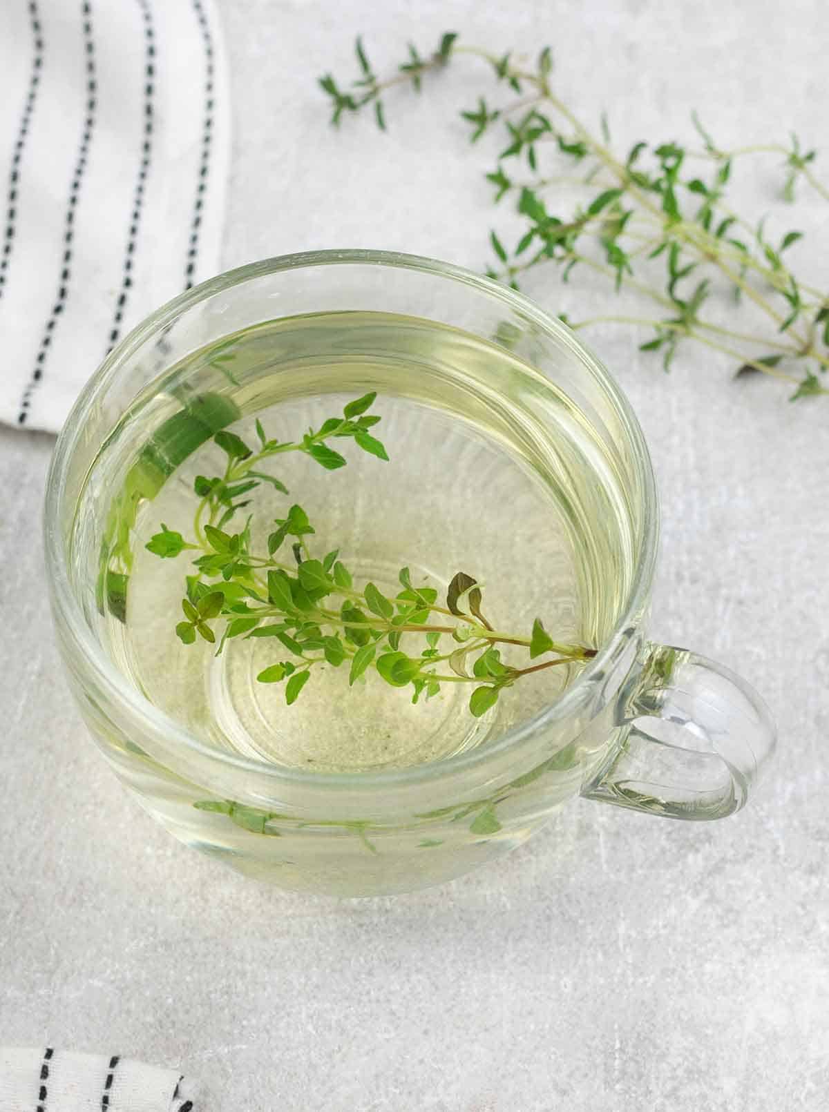 Thyme Tea with fresh Thyme sprig in the background