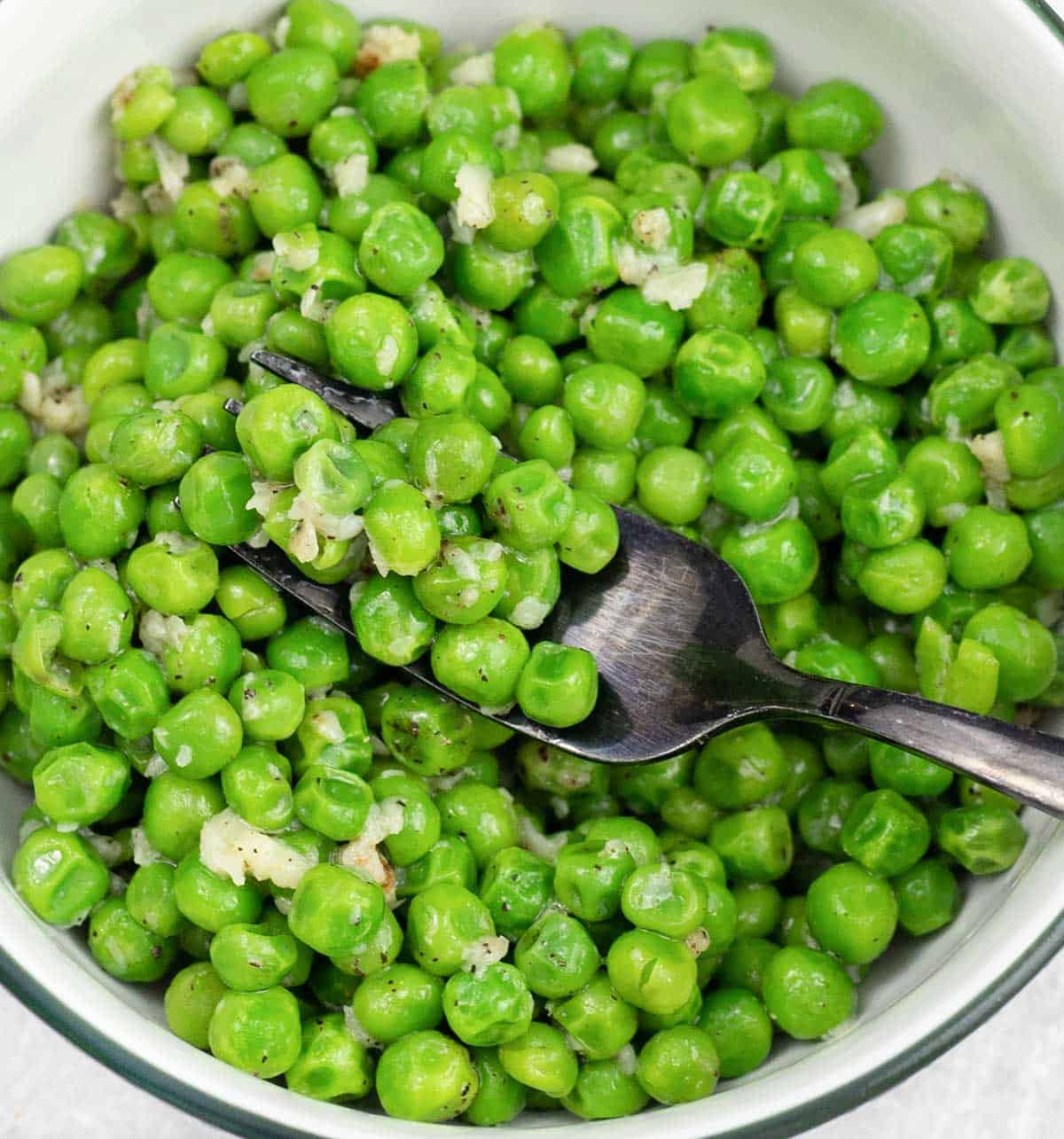 a spoonful of buttery peas with garlic and butter!