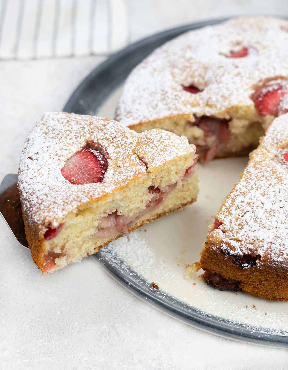 French Strawberry Cake slice topped with Strawberries and powdered sugar.