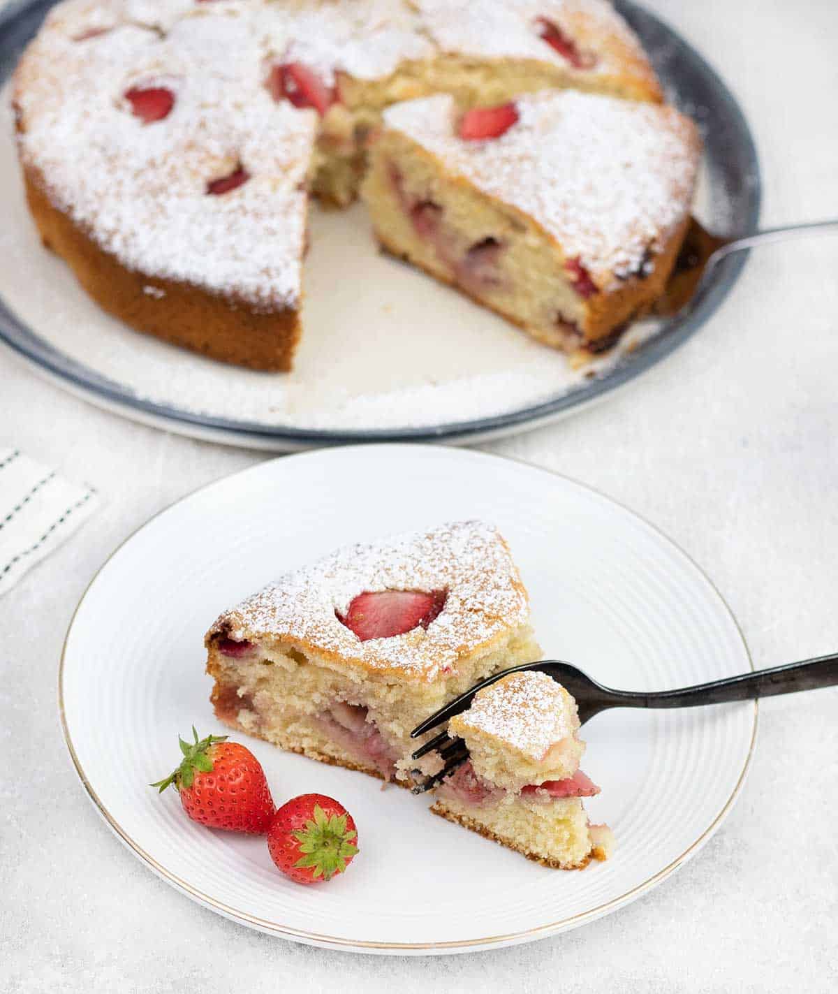 French Strawberry Cake slice in a plate along with some fresh strawberries.