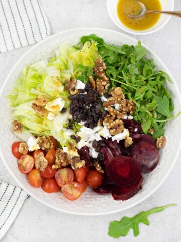 Goats cheese and beetroot salad with toasted walnuts on a plate.