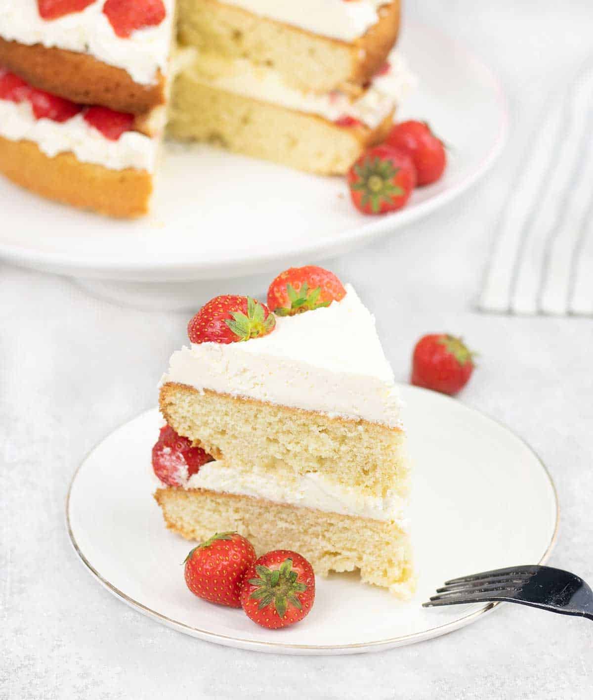 slice of Strawberry Sponge Cake and the whole cake in the background