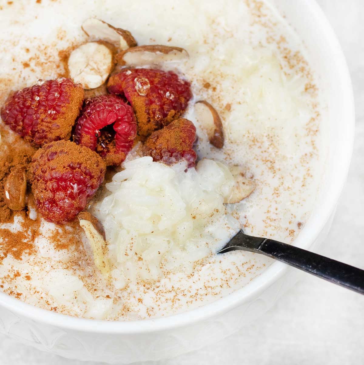 Sweet Rice Porridge in a bowl topped with berries.