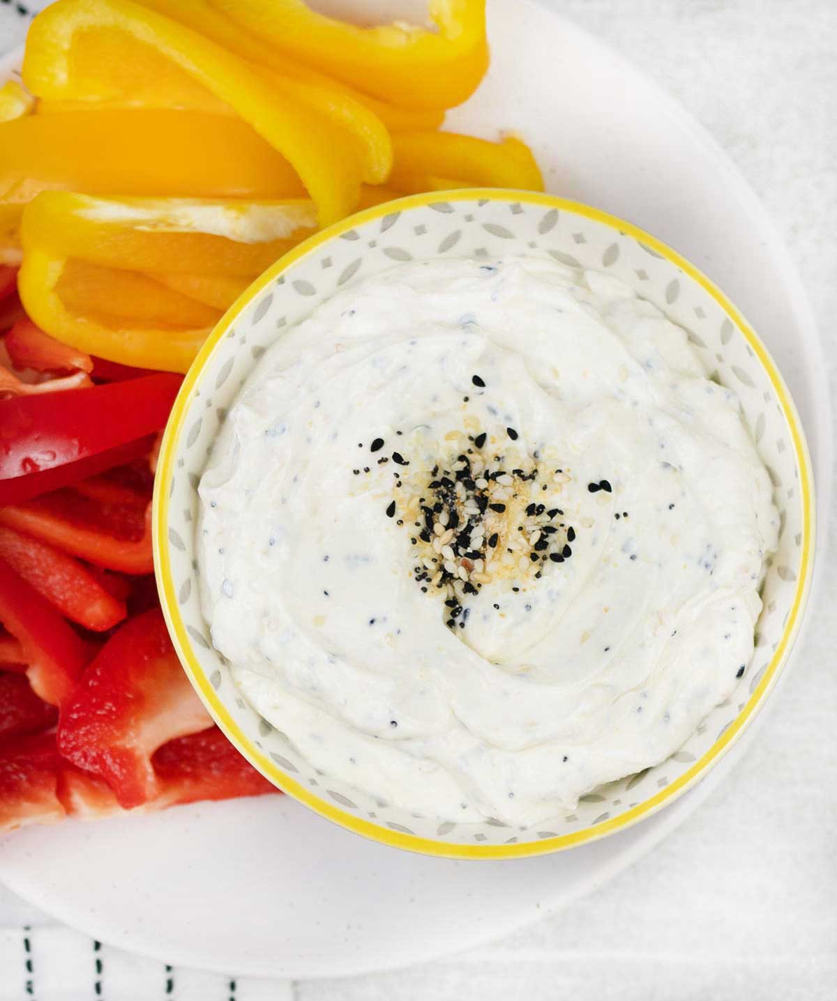 Bagel dip topped with everything bagel seasoning and some bell pepper slices.