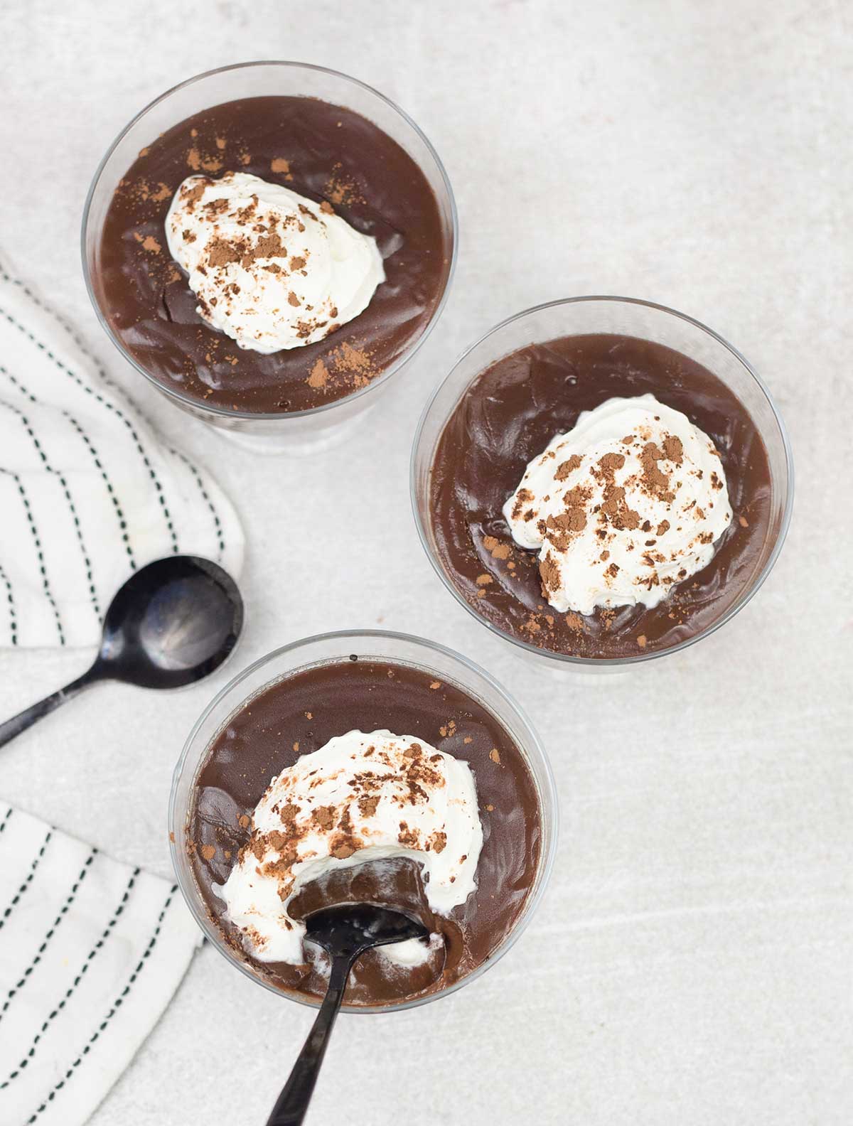 3 Chocolate Pots topped with whipped cream and cocoa powder.