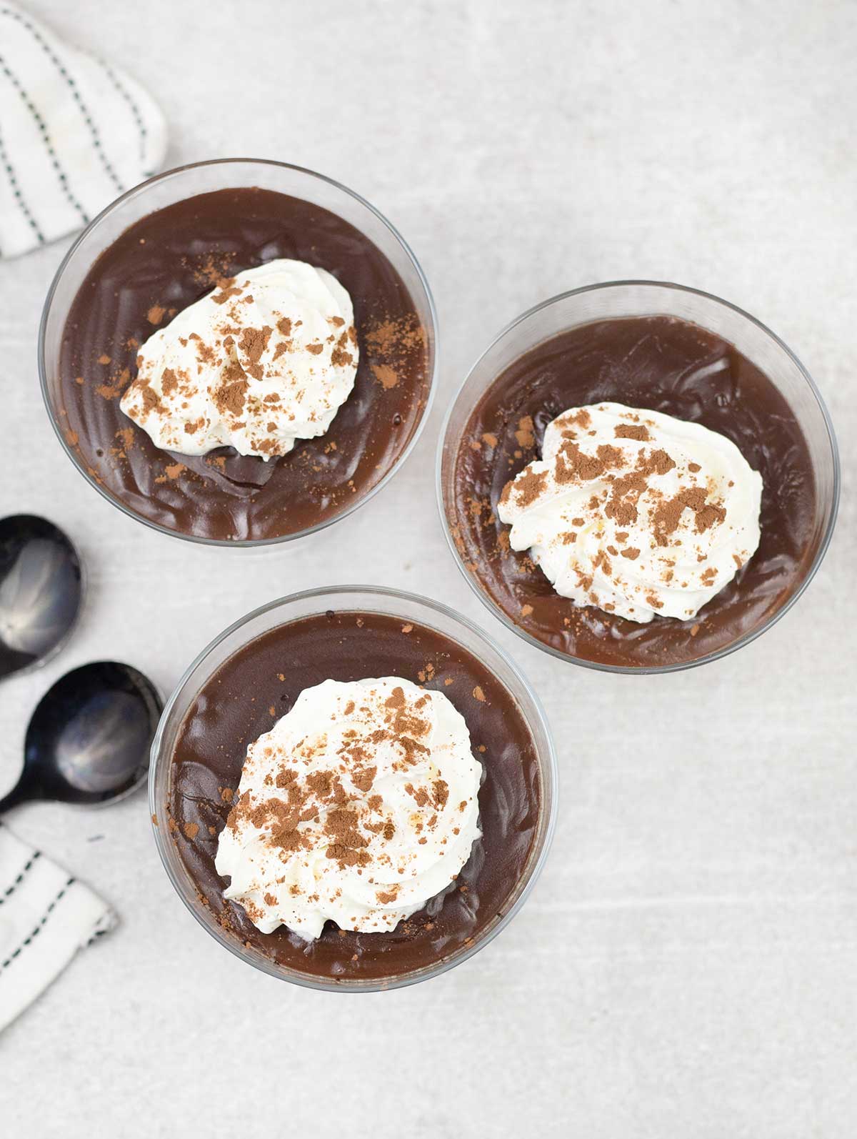 3 Chocolate Pots topped with whipped cream and cocoa powder.