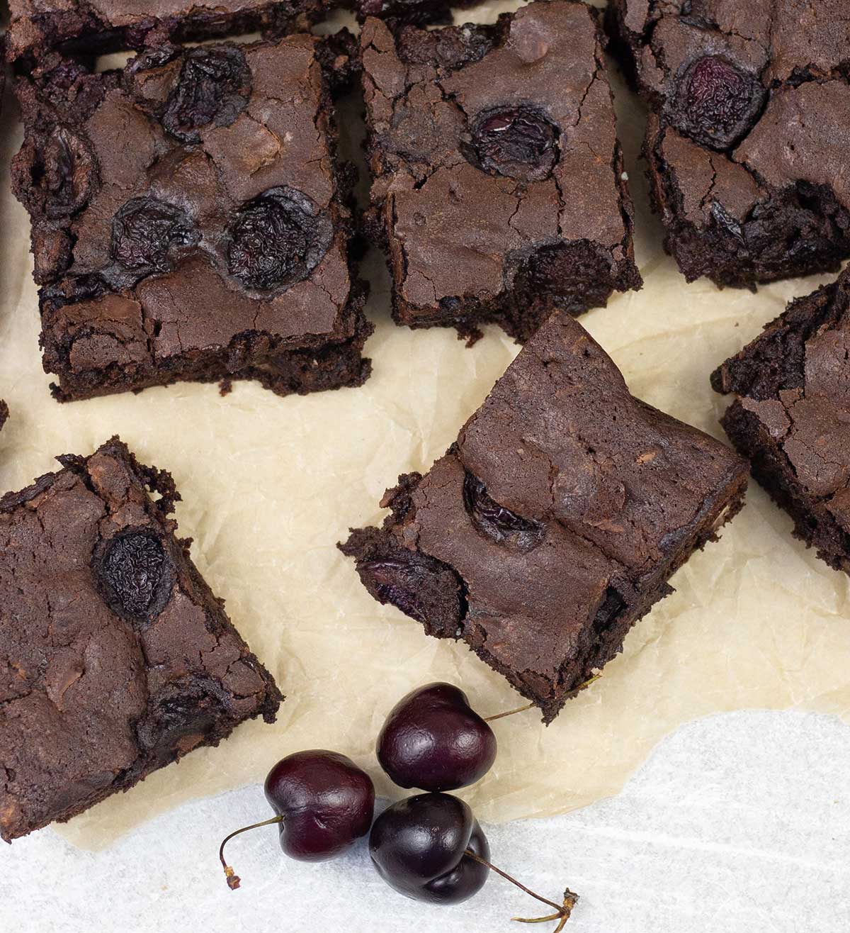 Overhead shot of cocoa cherry brownies and some cherries.