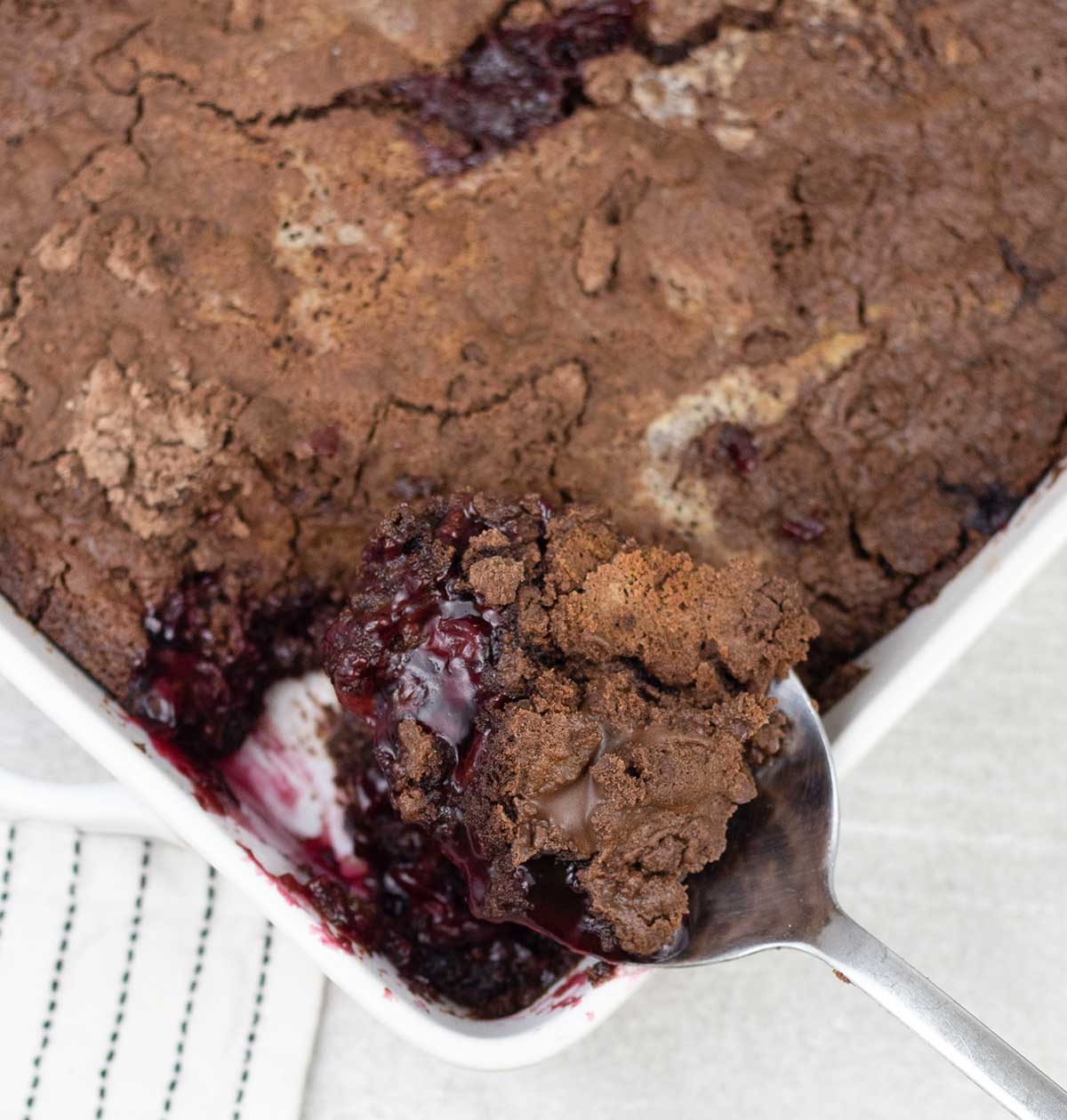 Chocolate cherry dump cake with cherry pie filling in a baking pan.