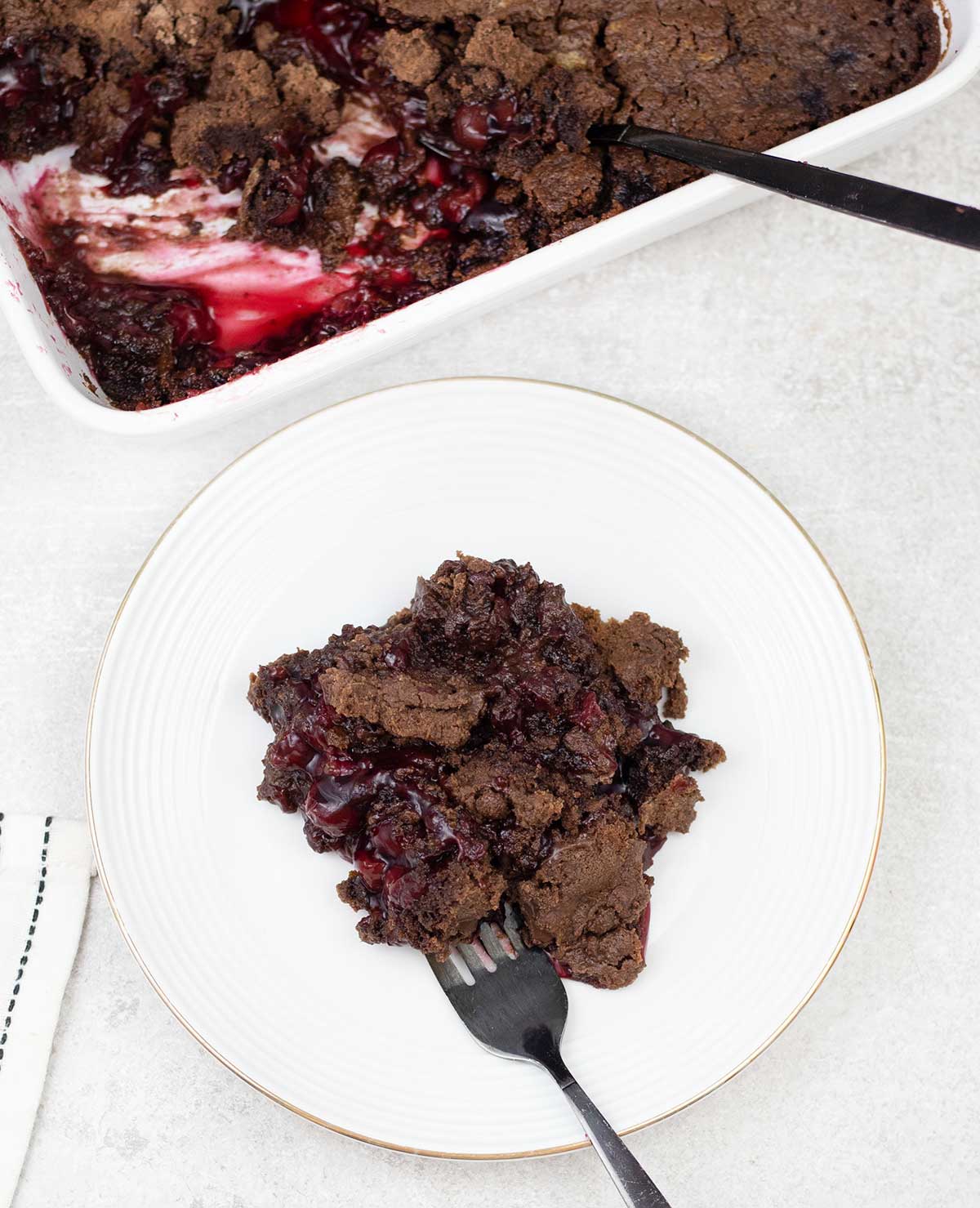 Chocolate cherry dump cake with cherry pie filling in a serving plate.