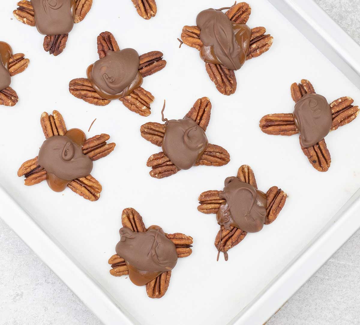 Turtle chocolate candy on a baking sheet.