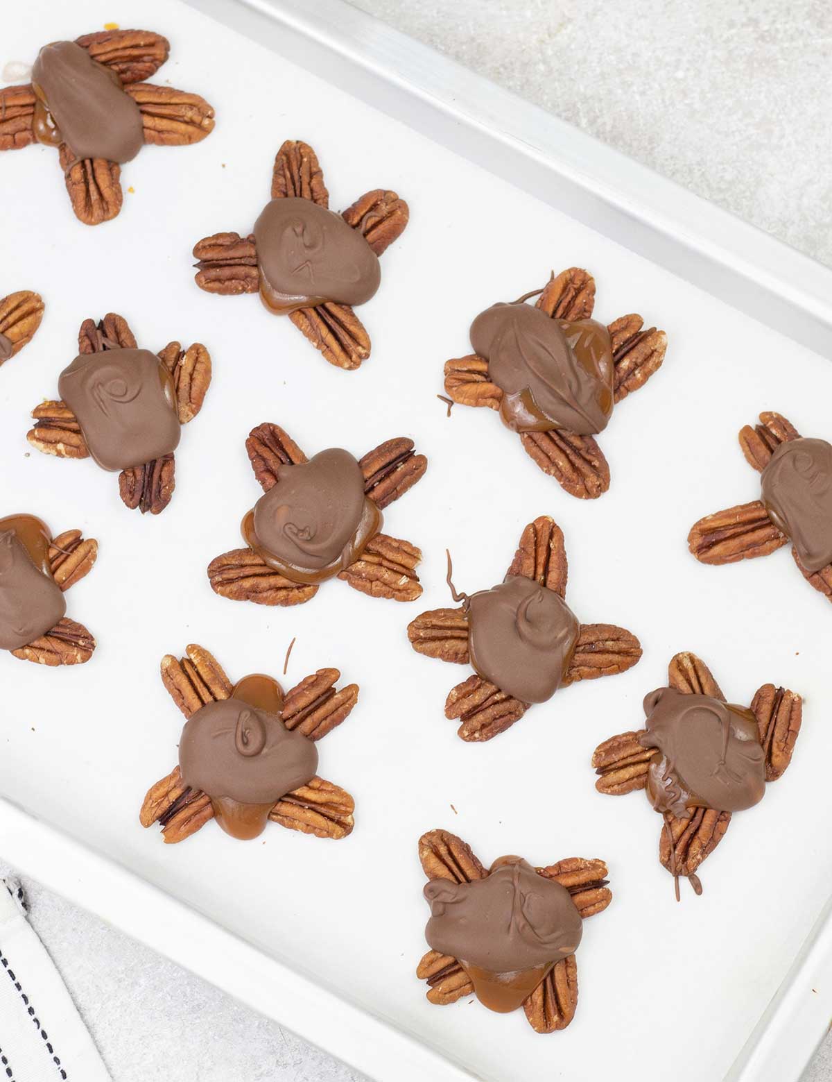 Turtle chocolate candy on a baking sheet.