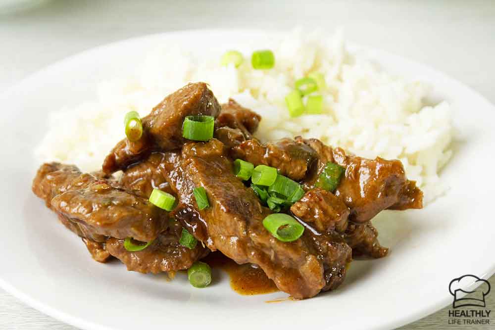 Chinese chilli beef and white rice in a serving plate.
