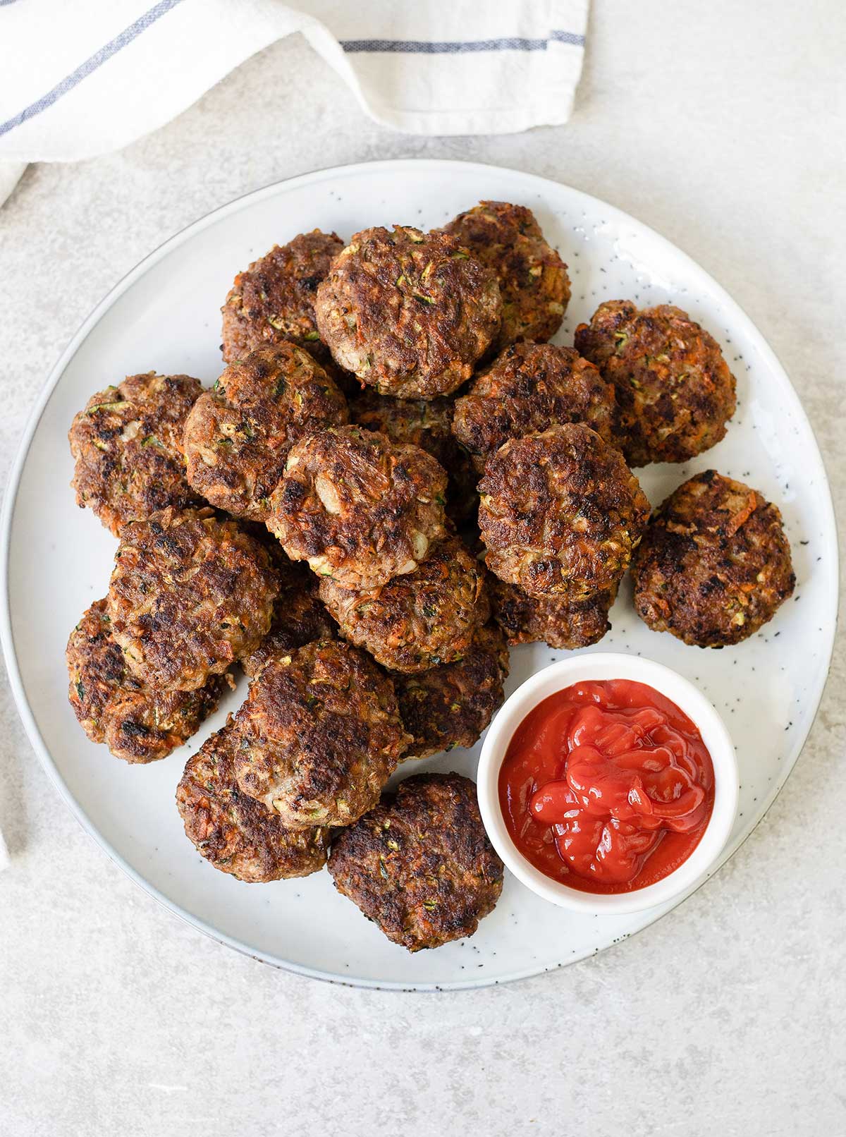 Beef Rissoles and a small bowl of ketchup.