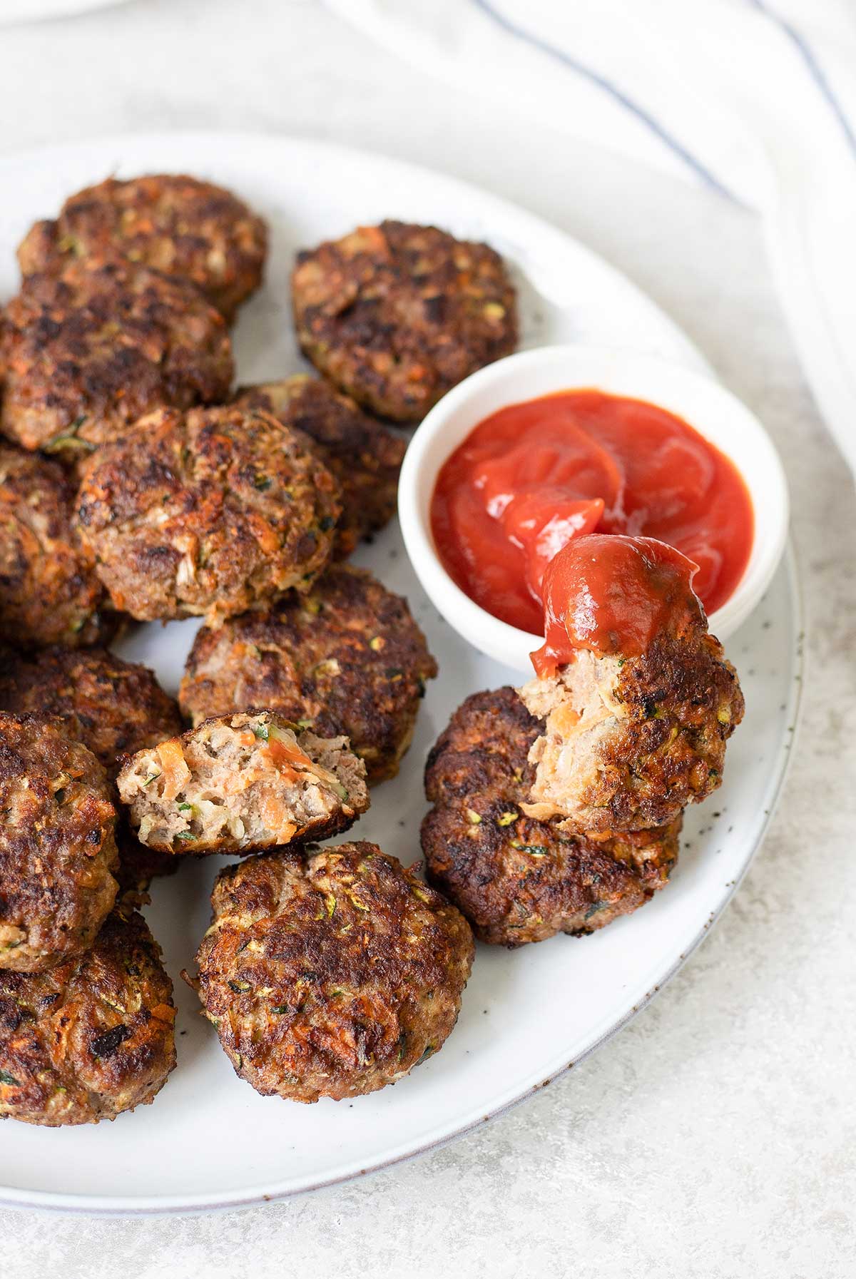 Beef and veggie Rissoles and a small bowl of ketchup.