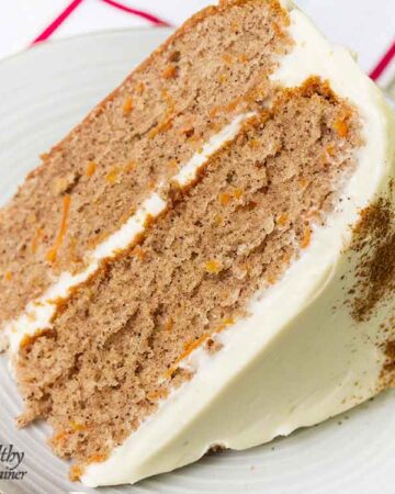 Simple carrot cake slice topped with cream cheese frosting.