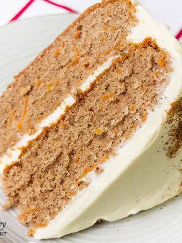 Simple carrot cake slice topped with cream cheese frosting.