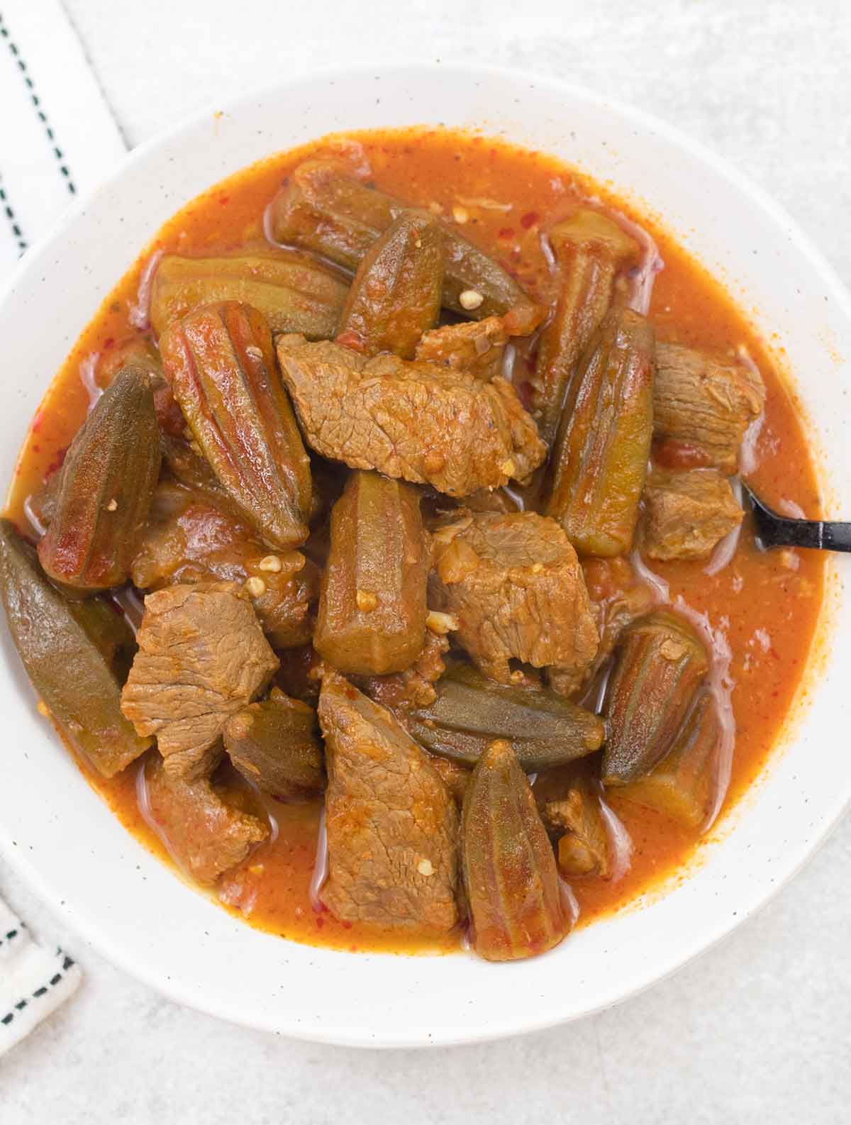 Bamya with beef in a serving bowl.