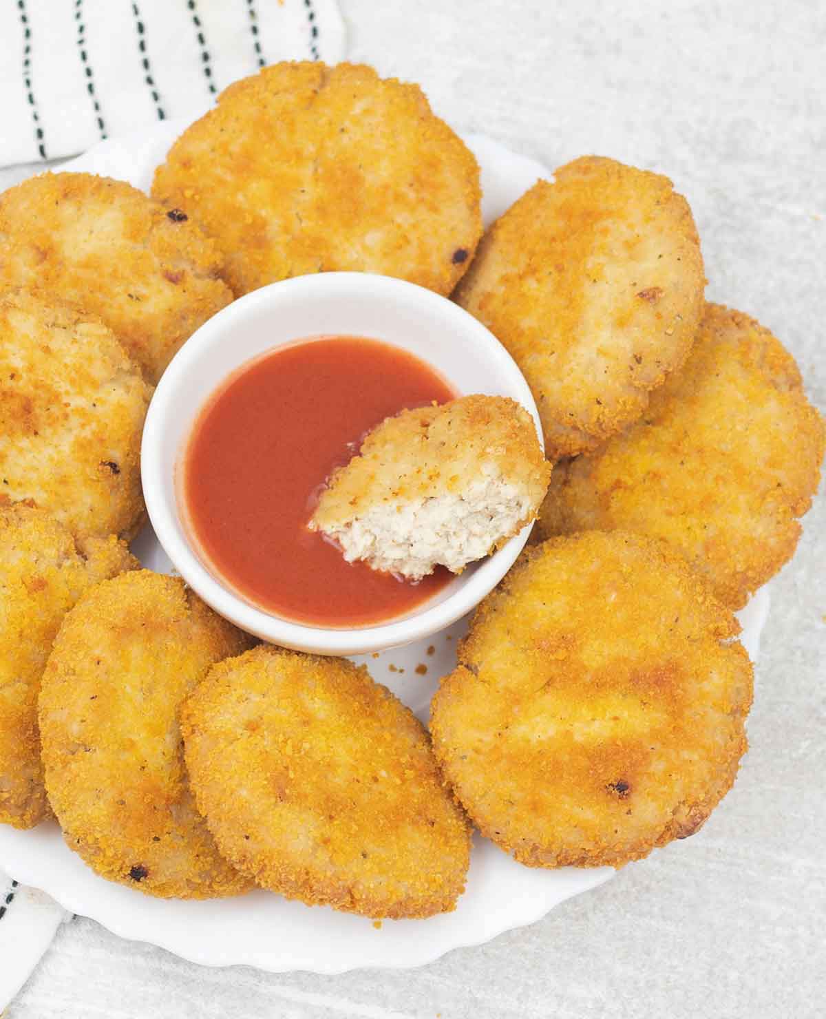 Crispy chicken patties and a small bowl of hot sauce.