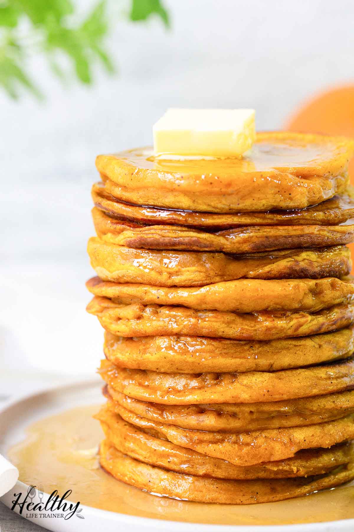 Fluffy pumpkin pancakes topped with butter and maple syrup.