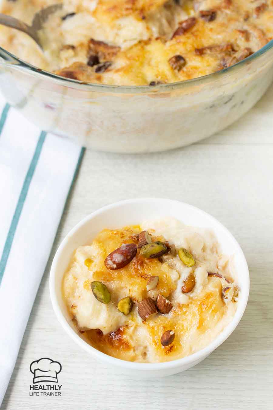 Om Ali dessert in a small bowl, topped with nuts.