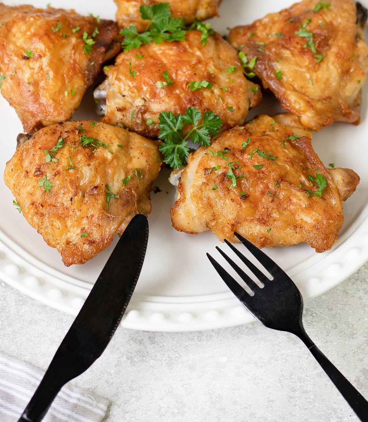 Bon in baked chicken thighs in a plate.