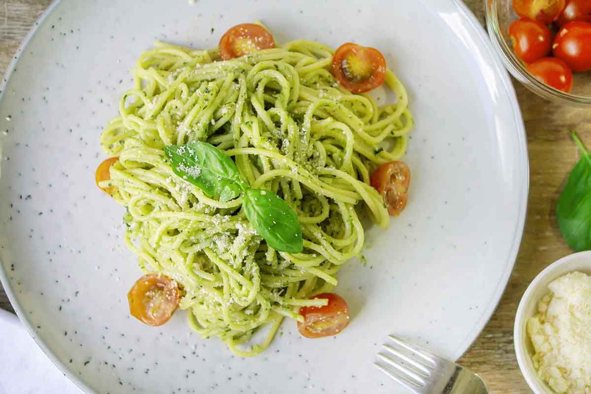 Creamy avocado sauce pasta topped with fresh basil and some cherry tomatoes.